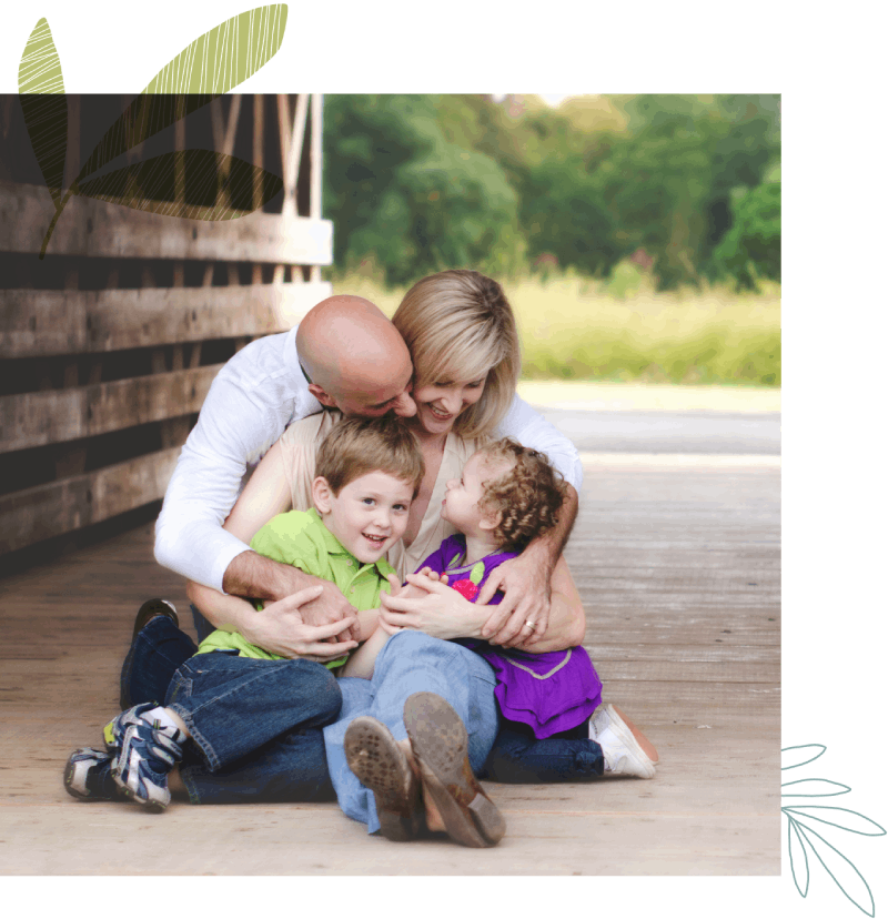 a family of a father, mother, son and dauther sitting all hugged